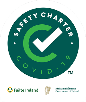 alt="COVID-19 Safety Charter logo featuring a green circle with a checkmark, symbolizing compliance with health and safety standards set by Fáilte Ireland and the Government of Ireland."