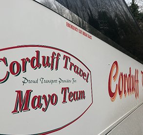 Side view of a Corduff Travel bus featuring the text "Corduff Travel" and "Mayo Team," showcasing the company's branding and transport services.