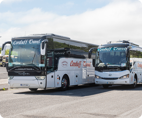 Two modern coaches from Corduff Travel parked side by side, showcasing their sleek designs and branding.