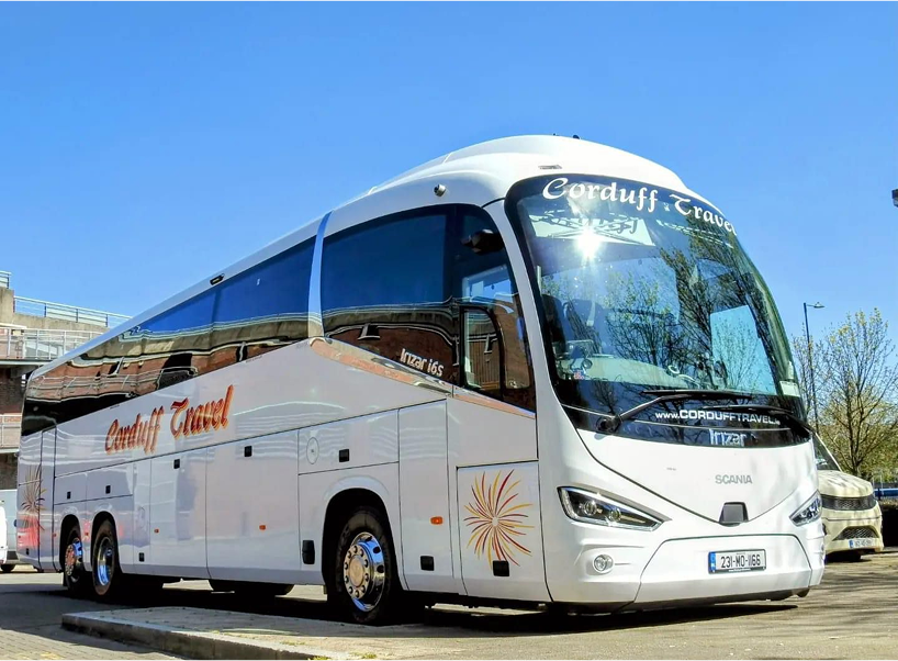 Alt text: Modern Scania coach bus with "Carduff Travel" branding parked in a sunny urban setting.